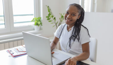 Young healthcare professional studying free online health courses on a laptop