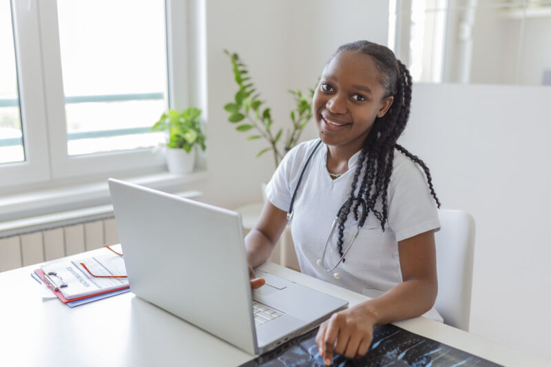 Young healthcare professional studying free online health courses on a laptop