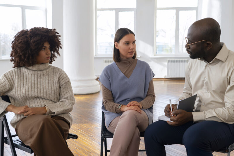 A mental health career professional leading a group therapy session with clients