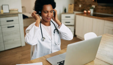 Healthcare professional working in remote medical jobs from home using a laptop for virtual patient consultations