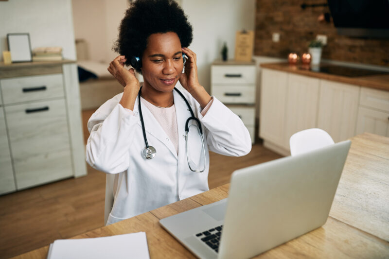 Healthcare professional working in remote medical jobs from home using a laptop for virtual patient consultations